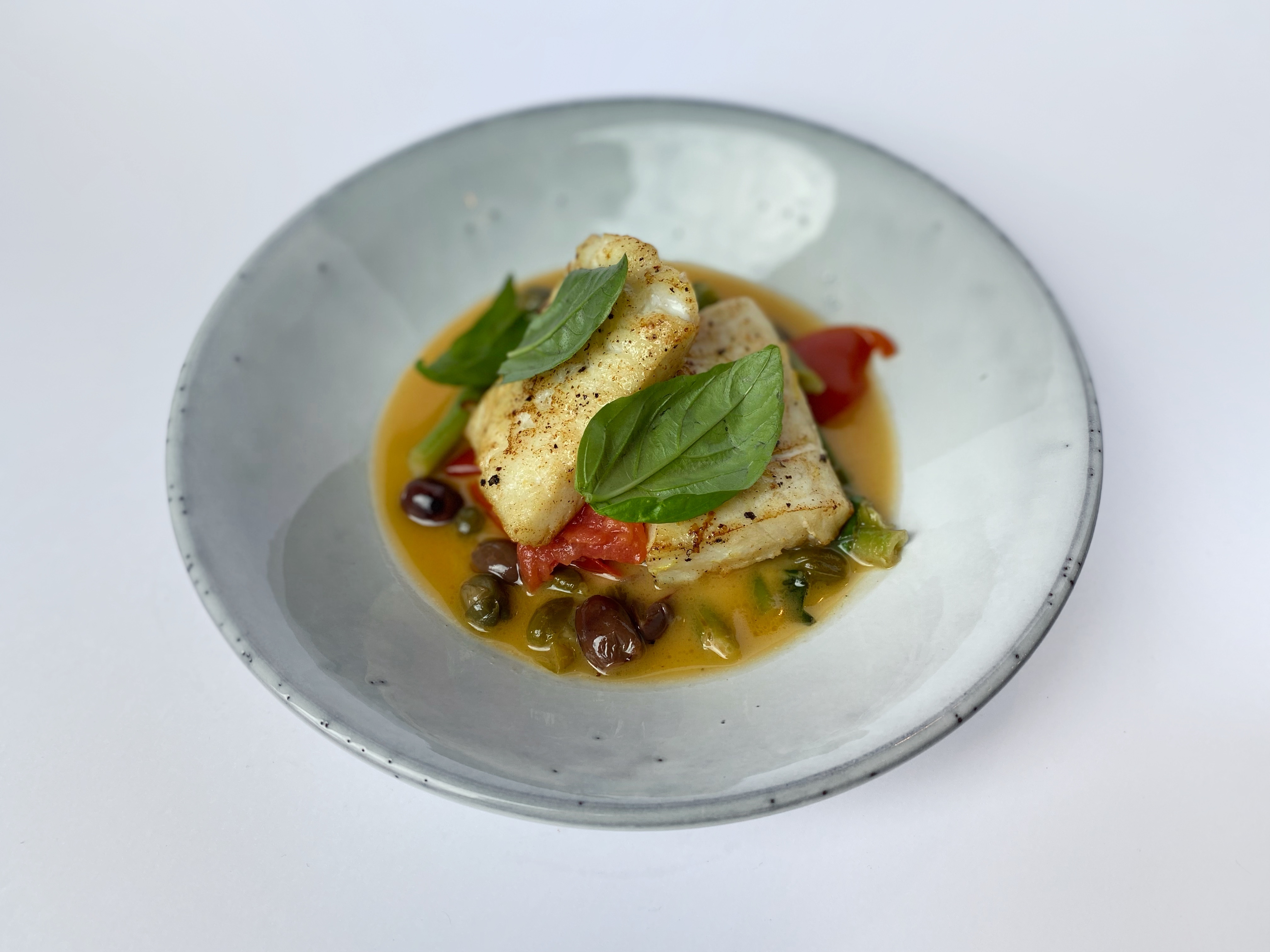 Cod fillet with sauteed tomatoes, olives, capers and Kenyan beans