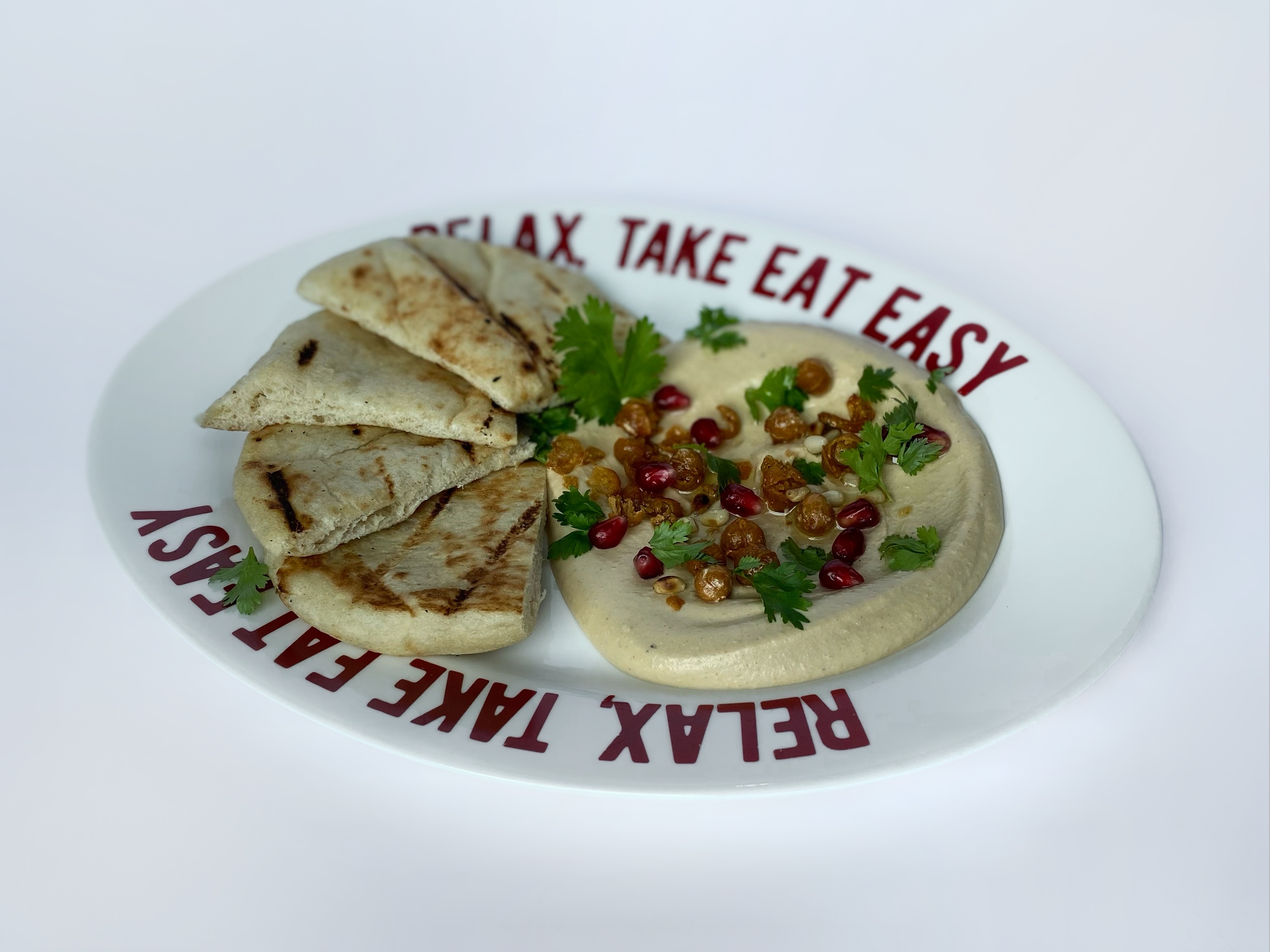 Hummus with pomegranate seeds, fried chickpeas, pine nuts and pita<br>